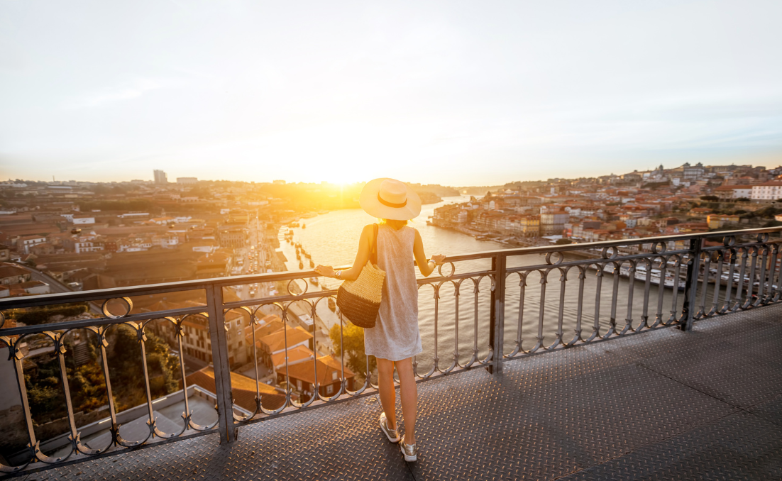 Mulher olhando o porto do sol de cima da ponte Luis I entre o Porto e Gaia