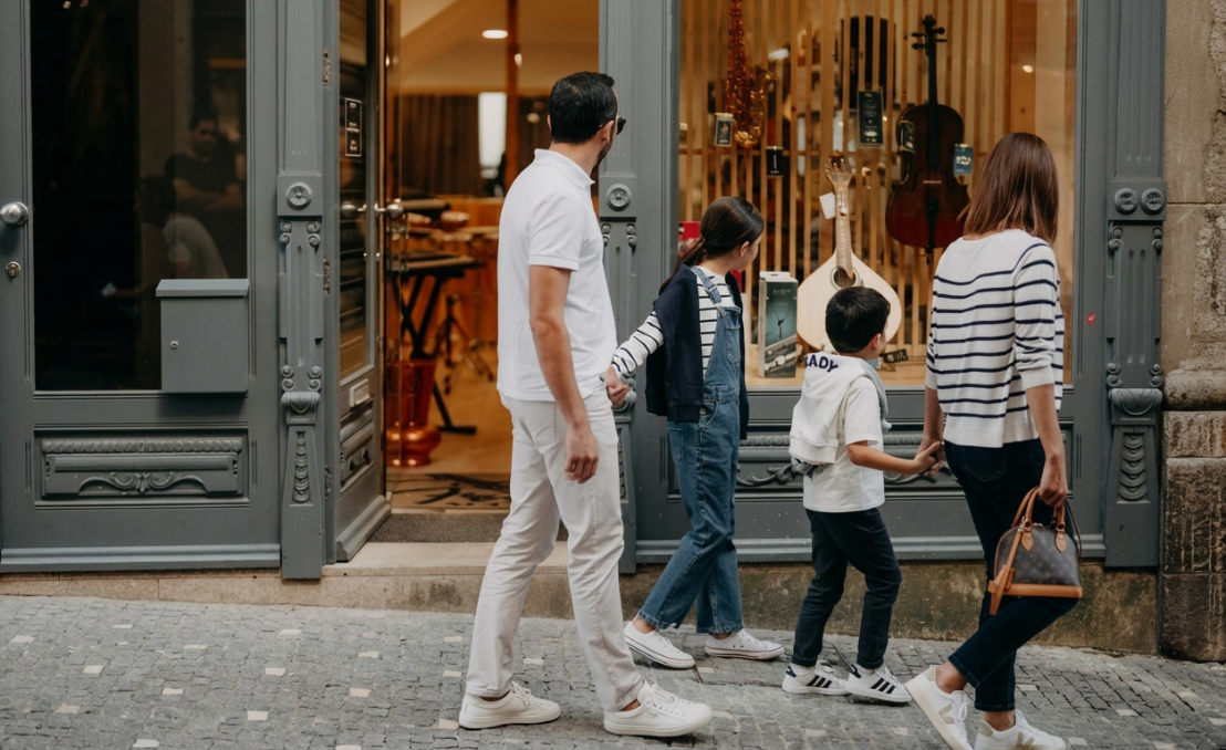Familia observando el escaparate de una tienda de instrumentos musicales en Rua do Almada, Oporto