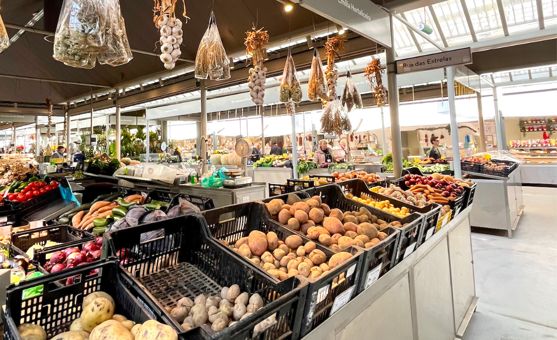 Mercado com bancas de frutas, legumes e produtos frescos no Porto