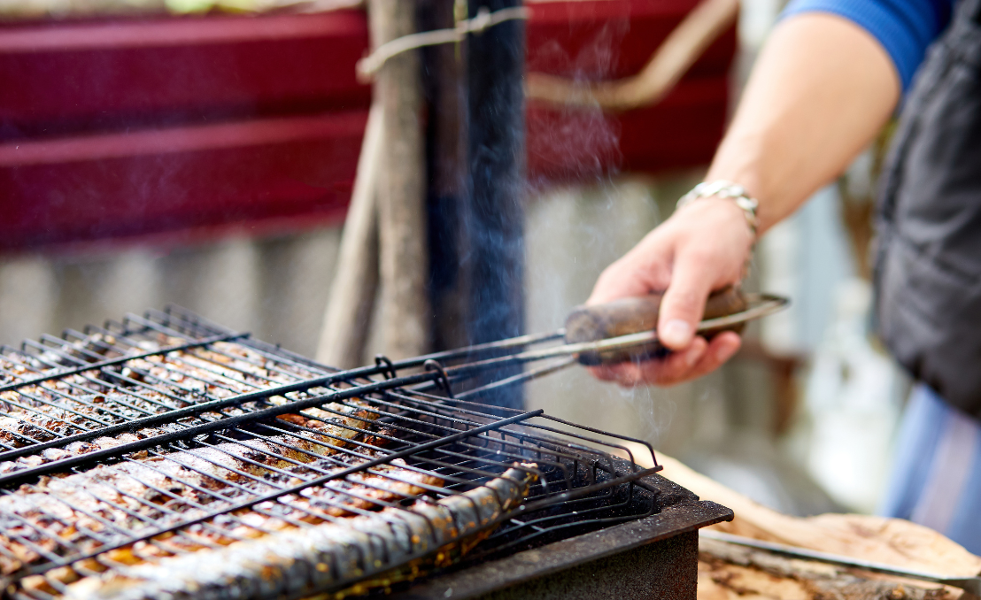 : Sardinas asándose a la parrilla durante las fiestas de San Juan en Oporto