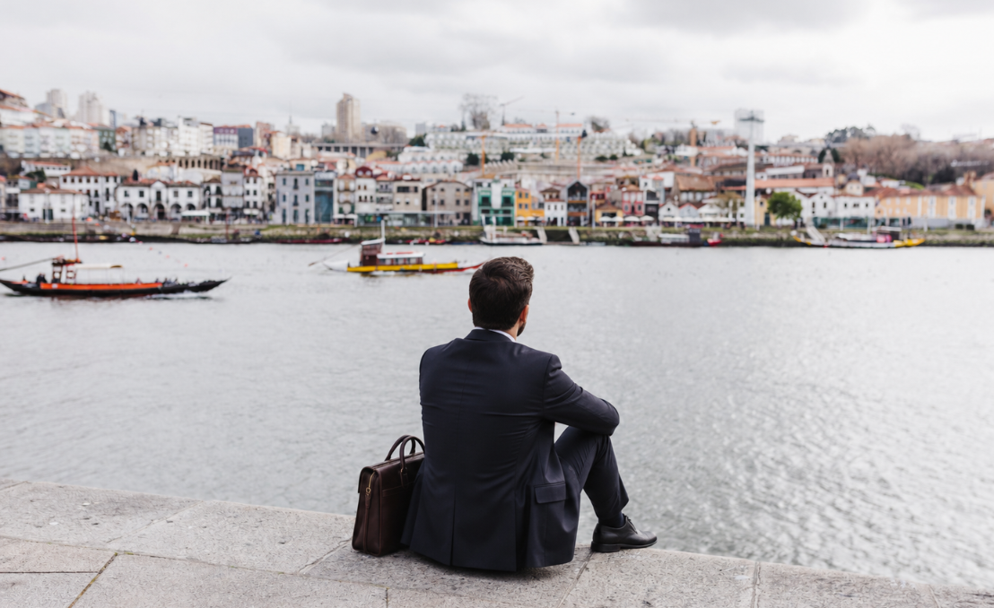 Homem de negócios junto ao rio Douro com vista para o Porto